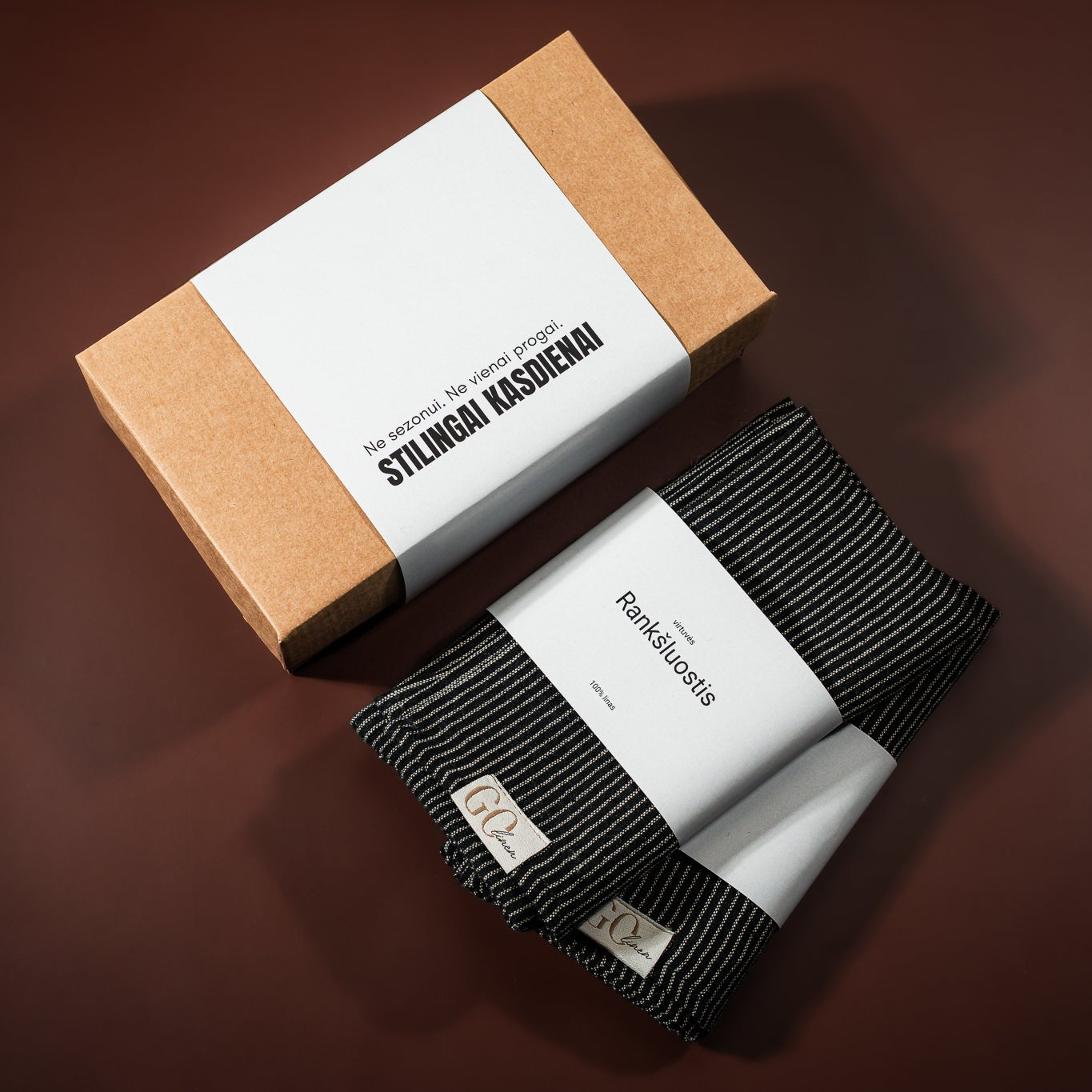 du lininiai virtuvės rankšluostukai, . juodia dryžuoti. Šalia padėta įpakavimo dėžutė