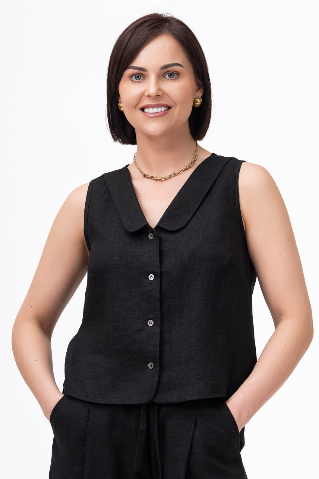 juoda lininė liemenė, V formos iškirptė,  kalnieriukai, susegama su sagomis. Vaizdas iš priekio