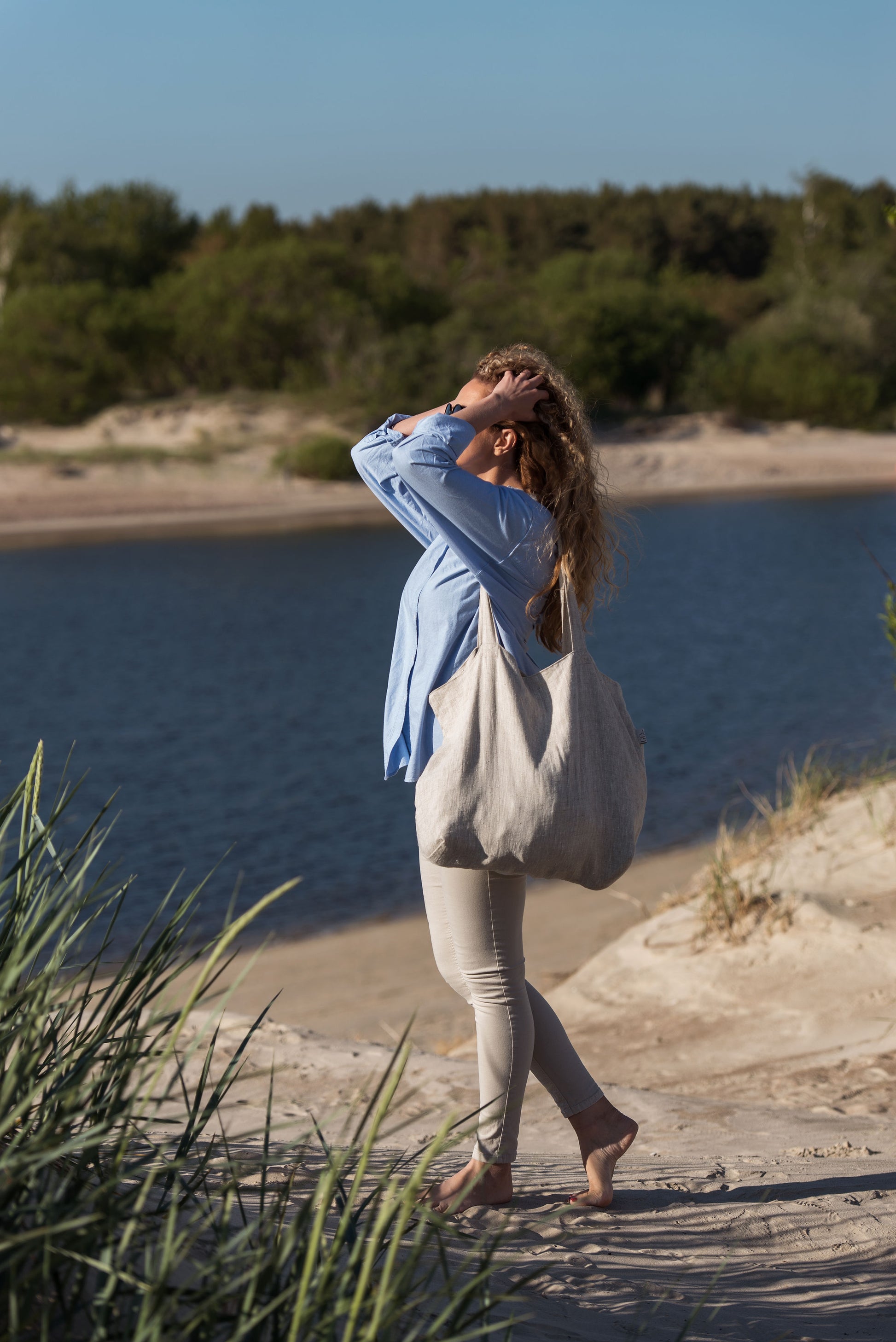 women in the beach with large tote bag on the shoulder